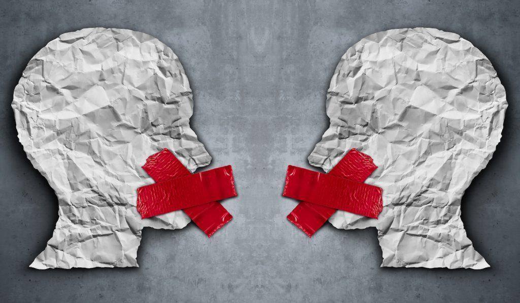 An image made from paper showing two heads with red tape across their mouths