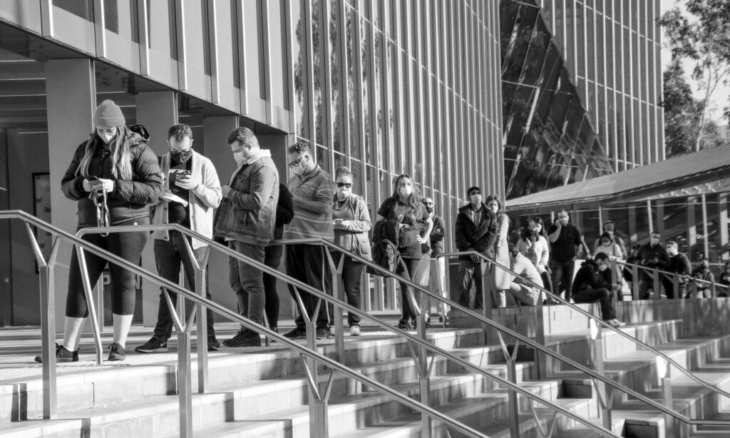 A line of people wait outside the steps of the Melbourne Convention Centre vaccination clinic during the Covid-19 pandemic in Melbourne.